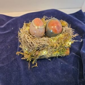 Two large polychrome eggs in a lighted nest