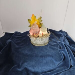 Two fluorite pumpkins with fall leaves on a lighted stand