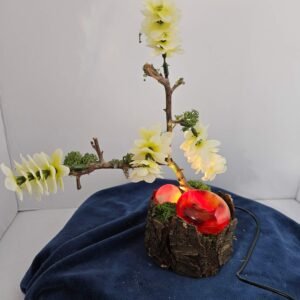 Two carnelian palmstones, one druzy, with flowers on a lighted stand