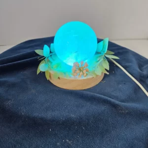 3-inch rainbow fluorite sphere on a lighted stand with flowers