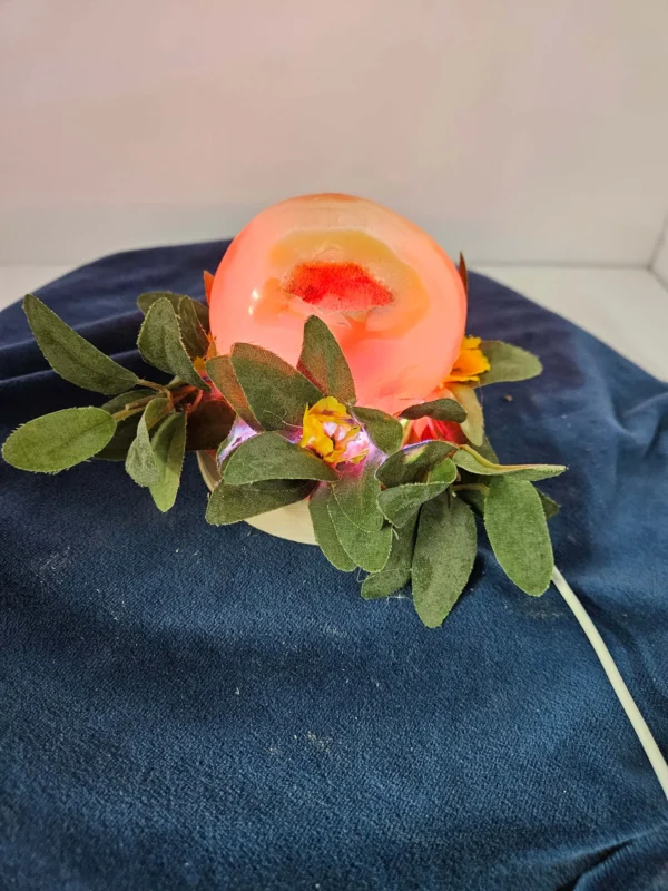 Druzy carnelian freeform on a lighted stand with flowers