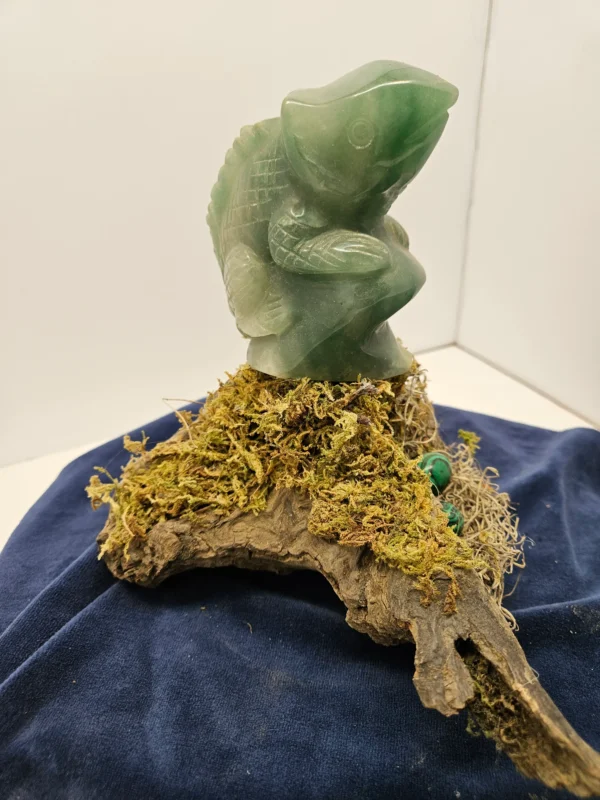 green adventurene lizard withe imitation malikite eggs on driftwood